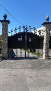 a black metal gate with two stone pillars at Villa Emanuel White in Sorrento
