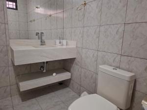 uma casa de banho com um WC branco e um lavatório. em Casa/Sobrado em Araraquara-SP em Araraquara
