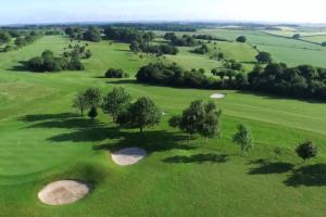 an overhead view of a green golf course with trees at The Nook, Cosy 1BR in Blandford, Dorset in Blandford Forum