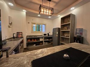 a large kitchen with a counter and a refrigerator at Boulevard Palace in Sheikh Zayed
