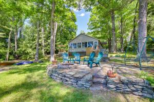 a tiny house in the woods with chairs and a stone wall at Lakefront Bradford Cottage with Dock, Near Skiing! in Bradford
