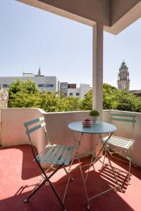 a table and a chair on a balcony with a view at Almada Charm Suites & Apartments in Porto