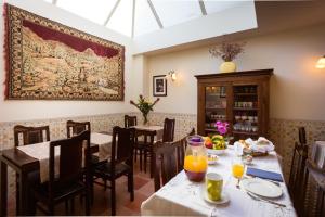a dining room with tables and chairs and a painting on the wall at Old City Guest House in Braga +42 photos