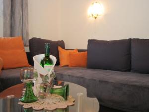soggiorno con divano e bottiglia di vino sul tavolo di Modern apartment with garden near the Petzen ski area in Eberndorf Carinthia a Eberndorf