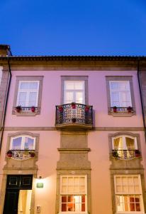 ein großes Gebäude mit Fenstern und einem Balkon in der Unterkunft Old City Guest House in Braga