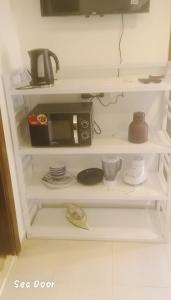 a white shelf with a microwave on top of it at شاليه سويت بلو باي مطروح chalet suite blue bay matrouh in Marsa Matruh +11 photos