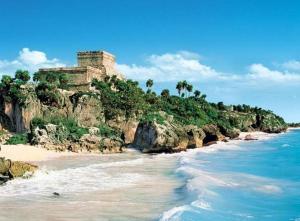 vistas a una playa con un edificio sobre un acantilado en Posada Malix Pek, en Tulum