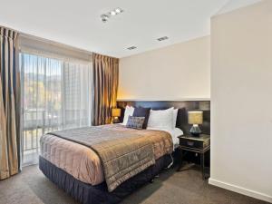 ein Hotelzimmer mit einem Bett und einem Fenster in der Unterkunft Clear Ridge Apartments in Hanmer Springs