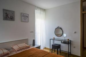 - une chambre avec un lit et un miroir dans l'établissement Lakeside Jarun Apartment, à Zagreb