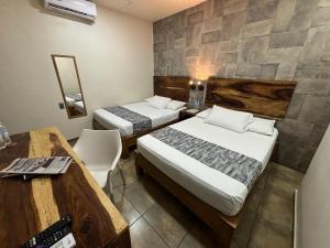 a hotel room with two beds and a table and chairs at 15 AVENIDA in Tapachula