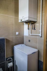 a small bathroom with a washing machine and a cabinet at Lakeside Jarun Apartment in Zagreb