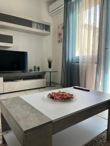 a table with a plate of food on it in a living room at Orchidea Home in Ravenna