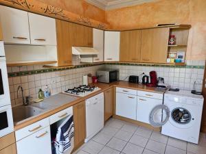 a kitchen with white cabinets and a washing machine at Charming 3-Bedroom House, Perfect for Family Getaways or Extended Professional Stays in Saâcy-sur-Marne