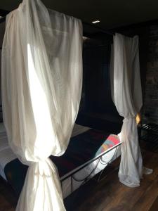a bed with white curtains on top of it at Helga's Guesthouse in Lin +92 photos