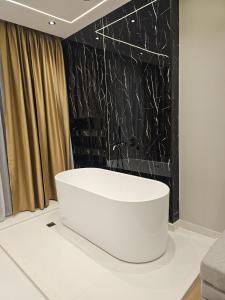 a white tub in a room with a black wall at Diol Hotel Ksamil in Ksamil