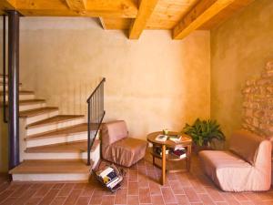 ein Wohnzimmer mit einem Stuhl, einem Tisch und einer Treppe in der Unterkunft Graceful Holiday Home in Acqualagna with Swimming Pool in Acqualagna