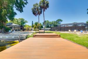 a wooden boardwalk in a park with palm trees and a building at Waterfront Villa with Pool about 5 Mi to Ybor City! in Tampa