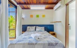 una camera da letto con un letto con asciugamani sopra di CS15 BANGALÔ DUPLEX frente ao mar Itacimirim a Camassari
