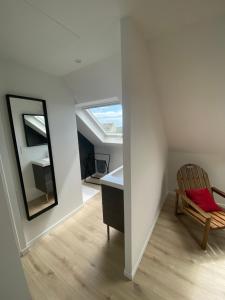 a room with a chair and a desk and a mirror at Vue Mer Très belle plage à pied Maison proche Lesconil Loctudy in Loctudy