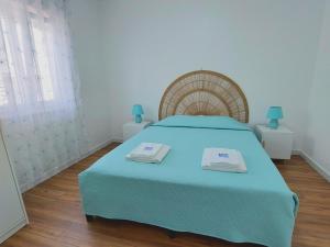 サンティアゴ・ド・カセーンにあるA Casa dos Azulejosのベッドルーム1室(ベッド1台、タオル2枚付)