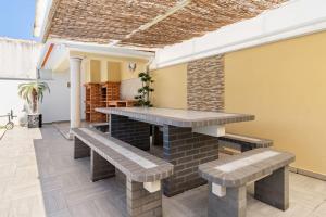 a patio with benches and a table in a room at Casa Nazare in Nazaré