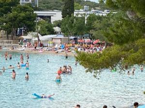 a group of people in the water at a beach at SEASPRAY APARTMENTS TISNO in Tisno