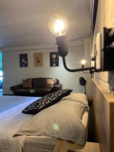 - une chambre avec un lit doté d'une lampe et d'un canapé dans l'établissement FRN101 Cozy loft located in a popular in Poblado, à Medellín