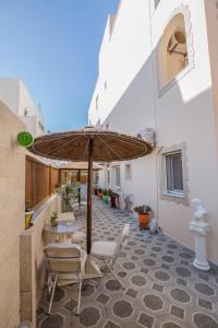 a patio with a table and an umbrella at Sweet Home in Karterados