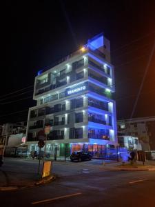 a tall building with blue lights on it at night at Apartamento próximo a praia no Tramonto bessa in João Pessoa