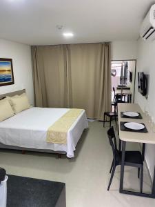 a bedroom with a bed and a table and chairs at Apartamento próximo a praia no Tramonto bessa in João Pessoa