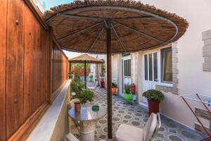 a patio with a table and an umbrella at Sweet Home in Karterados