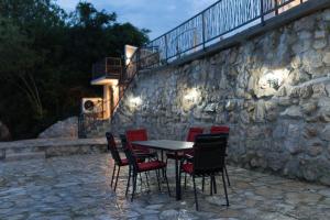 a table and chairs in front of a stone wall at Villa H in Blagaj +88 photos