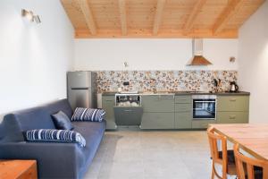 a living room with a blue couch and a kitchen at Villa Bazza in Riva del Garda