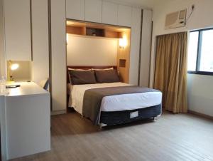 um quarto de hotel com uma cama e uma secretária em UH 1002 Flat Live Logde Vila Mariana Pq Ibirapuera em São Paulo