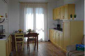 a kitchen with yellow cabinets and a table with chairs at Residenza Principina in Principina Terra