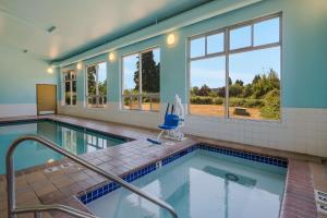 uma grande piscina com paredes e janelas azuis em Best Western Cottage Grove Inn em Cottage Grove