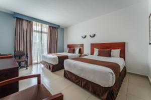 Pokój hotelowy z 2 łóżkami i biurkiem w obiekcie Hotel La Venta Inn Villahermosa w mieście Villahermosa