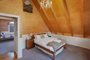 a bedroom with a bed and a chandelier at Kookas Cottage in Merrijig