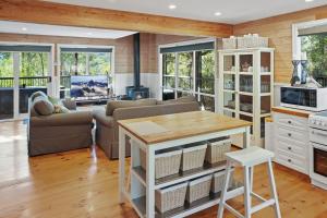 a living room with a couch and a table at Kookas Cottage in Merrijig +16 photos