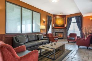 a living room with a couch and chairs and a fireplace at Best Western Strathmore Inn in Strathmore