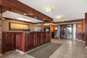 a lobby with a bar with wooden cabinets at Best Western Strathmore Inn in Strathmore