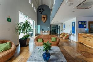a living room with two couches and a blue vase at Hotel La Venta Inn Villahermosa in Villahermosa