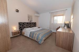 Schlafzimmer mit einem Bett, einem Schreibtisch und einem Fenster in der Unterkunft Hotel Paquito in Nova Gorica