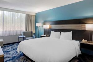 Best Western Rutgers University Hotel في إيست برونزويك: غرفة فندقية بسرير كبير وكرسي