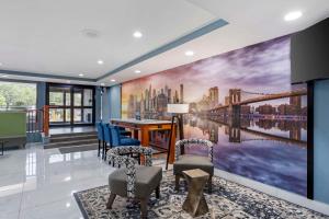 a living room with a painting of a bridge at Best Western Rutgers University Hotel in East Brunswick