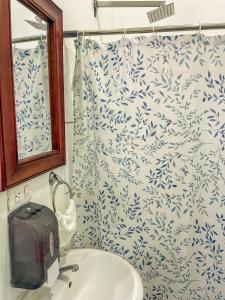 a bathroom with a blue and white shower curtain at Hostal Eden in Moyogalpa