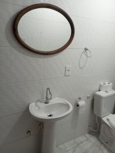 a bathroom with a sink and a mirror on the wall at Villa Pareto Guest House in Macaé +20 photos