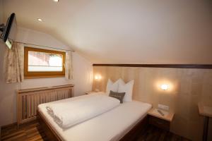 Un dormitorio con una cama blanca y una ventana. en Feierabendhof, en Ischgl