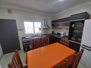 a kitchen with an orange table and chairs in it at Duplex Yrigoyen B in San Juan
