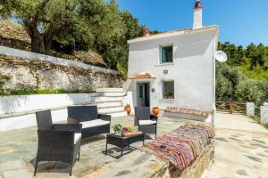 a patio with a couch and chairs and a building at The Mountain Majesty in Skopelos Town